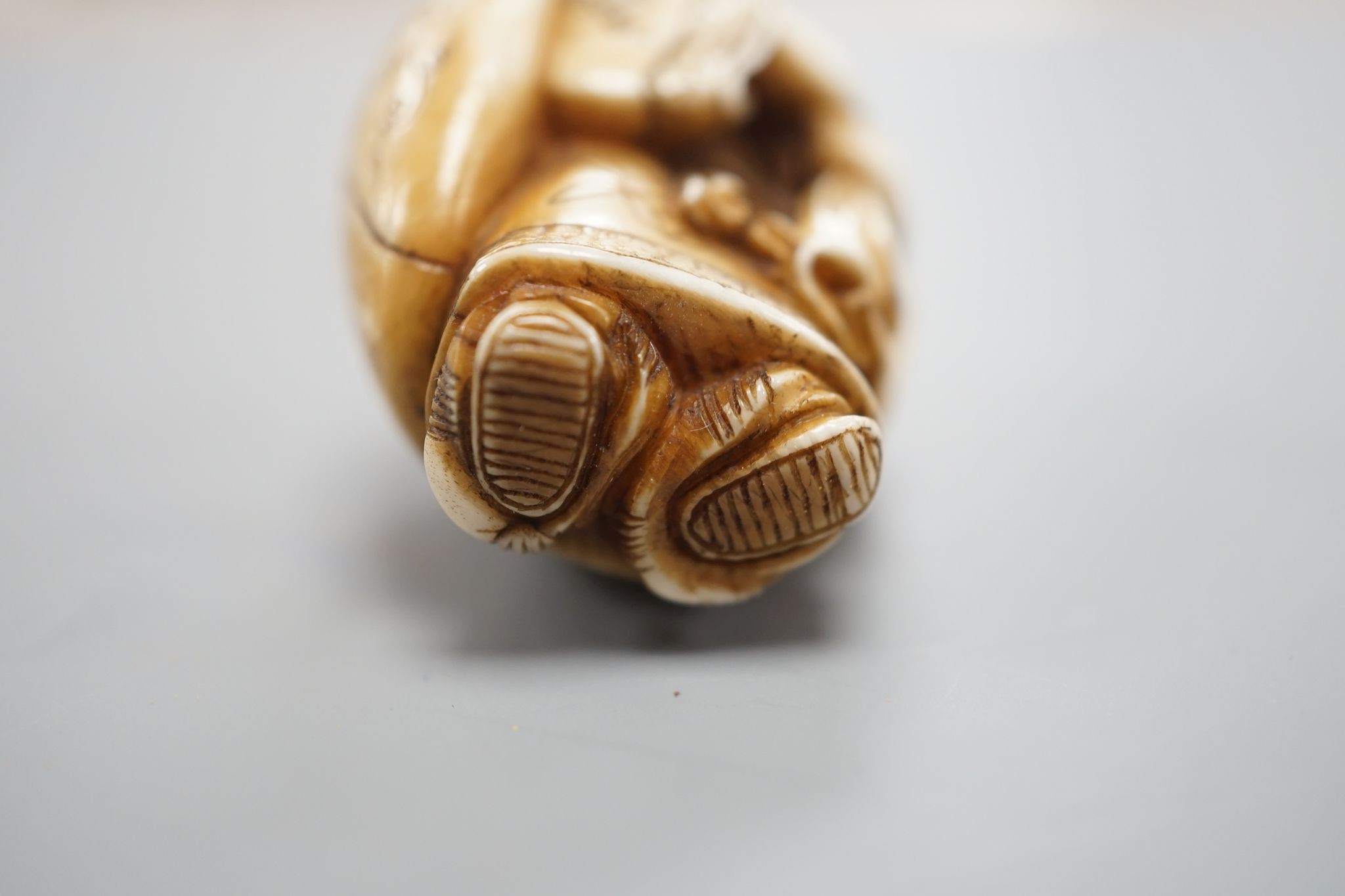 A Japanese ivory netsuke of Daikoku or Ebisu, Meiji period, 4 cms high.